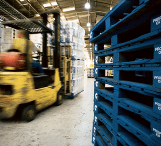 forklift lifting pallets in warehouse